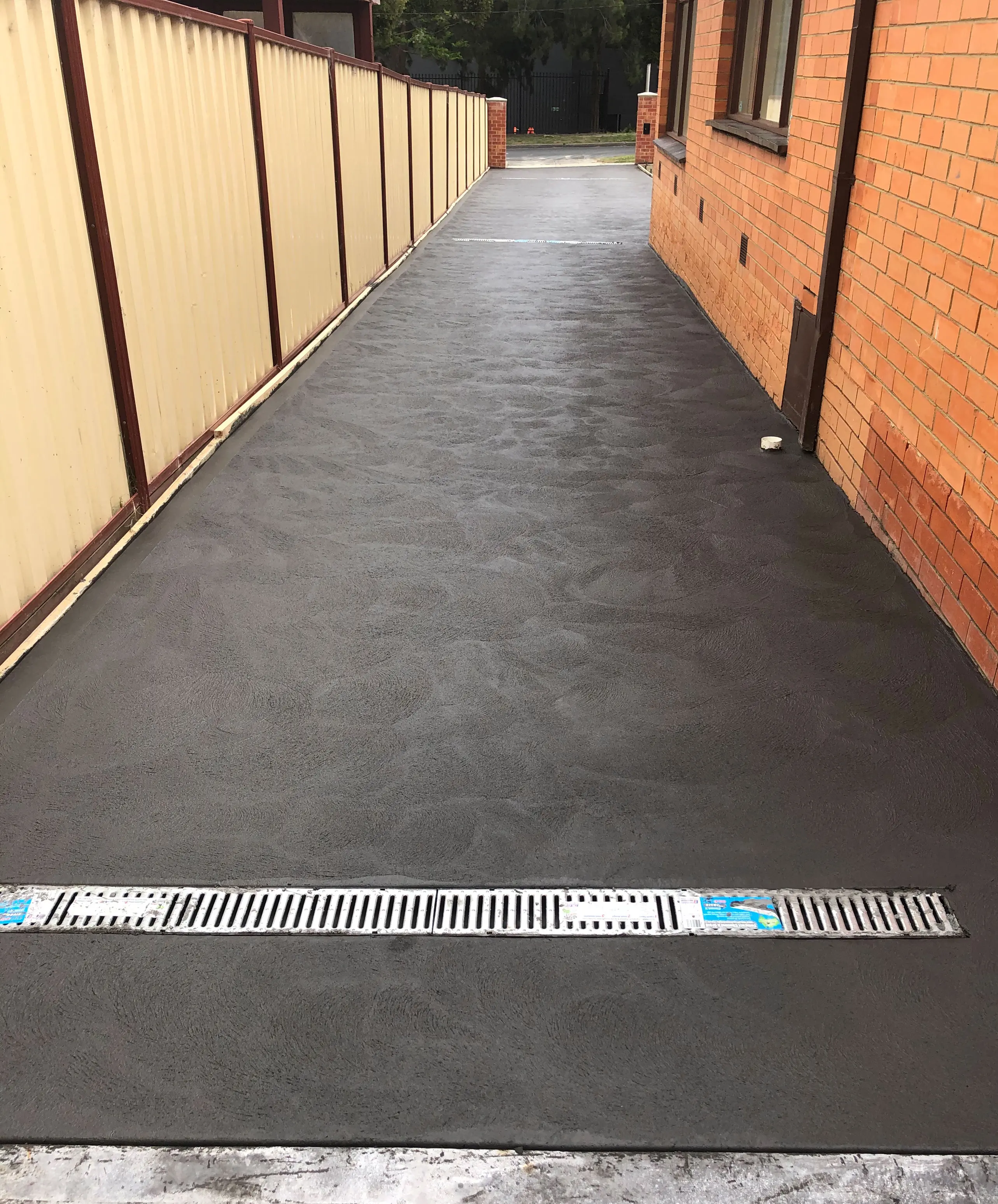 Modern coloured concrete driveway in Melbourne with smooth finish